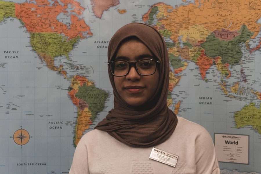 Noor Al Awaisi, a team leader of International Student Community Team, in front of a world map in the teams office in the Student Experience Center room 204.