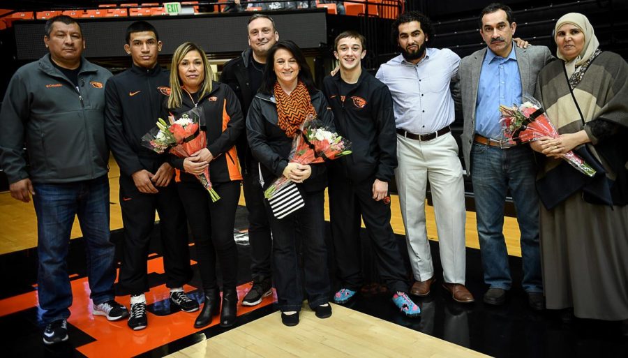(Left to right)  senior wrestlers Joey Delgado, Joey Palmer and Ali Alshujery pose with their family on Senior Night against CSU Bakersfield