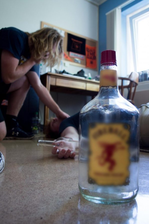 Two OSU students pose representing a potential situation where an intoxicated minor might need to call for emergency medical services for another intoxicated minor. The Oregon Medical Amnesty Law would protect them from MIP citations in this situation.