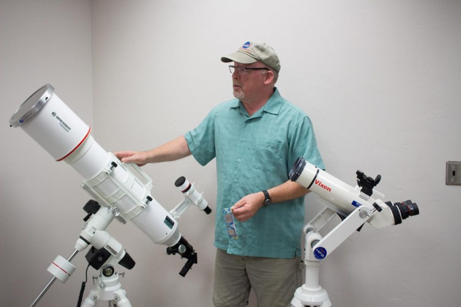 OSU astronomy professor Randall Milstein demonstrating a telescope used to examine the sun’s surface (left) and solar binoculars (right).