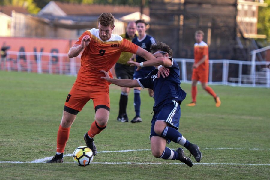 Senior forward Timmy Mueller stiff arms a defender as he makes his way toward the goal in an exhibition match against Trinity Western on August 17.