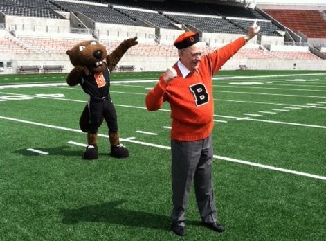 Ken Austin, the original Benny Beaver, poses with Benny Beaver on the field in Reser Stadium.
