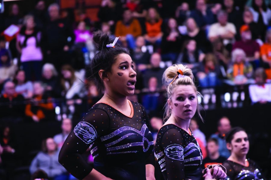 Sophomore Isis Lowery and former senior gymnast Madeline Gardiner waiting to compete in a gymnastics meet last season. 