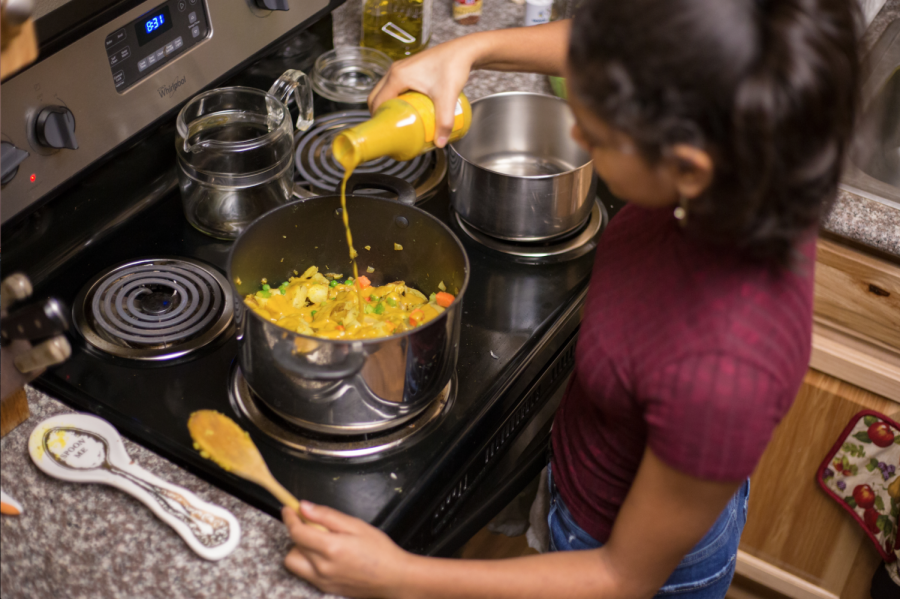 Aja Rayburn, a freshman at OSU majoring in philosophy and business management, makes a vegetable yellow curry for herself and friends. 