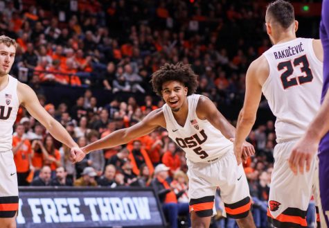 OSU sophomore guard Ethan Thompson gives his teammates Tres Tinkle (left) and Gligorije Rakocevic (right) high fives in their game against Washington. Thompson, Gligorije and Tinkle were all selected for Pac-12 All-Academic awards on Tuesday.