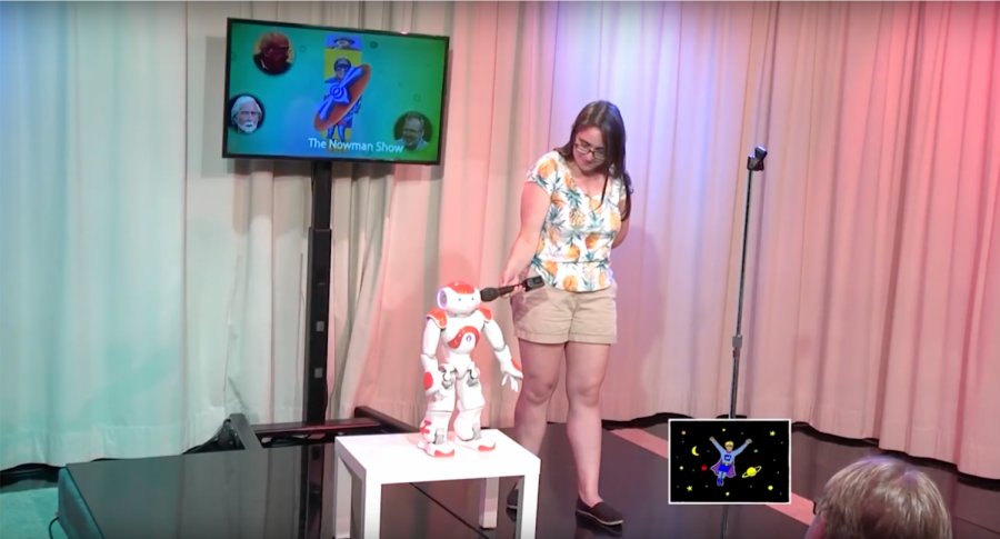 Assistant Professor Naomi Fitter holds a microphone to comedy robot Jon the Robot.