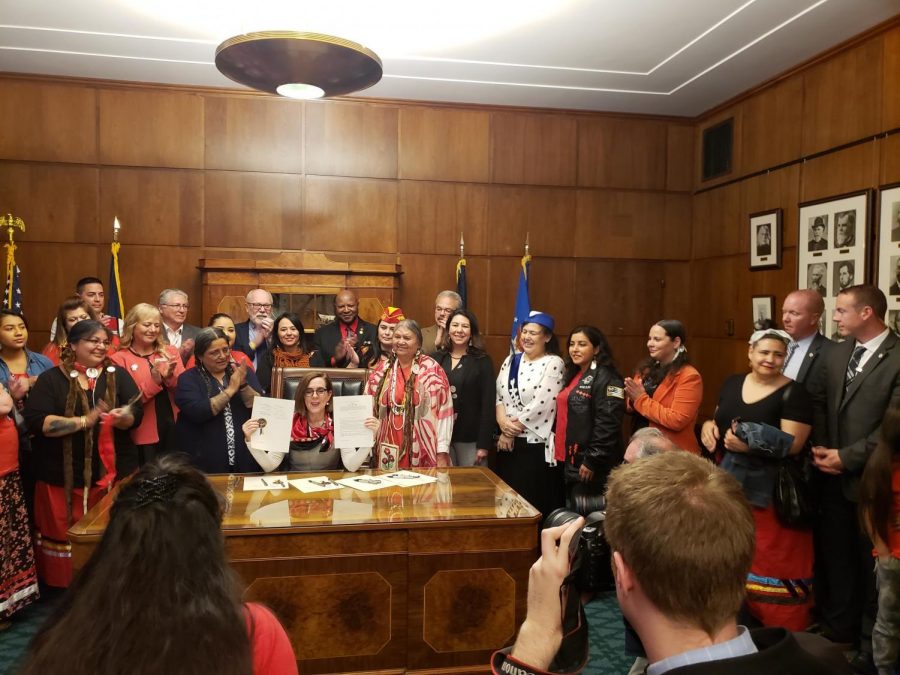 (Right) Luhui Whitebear watches as Oregon Governor Kate Brown signs a bill to launch an investigation within the state of Oregon asking the different law enforcement agencies, between the state and the Oregon tribal communities, to work together and recognize the extent of the issue of missing Native American women. 