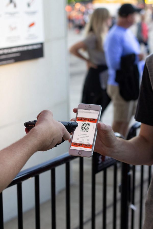 A student gets their ticket scanned at the student entrance for a football game in Reser Stadium. 