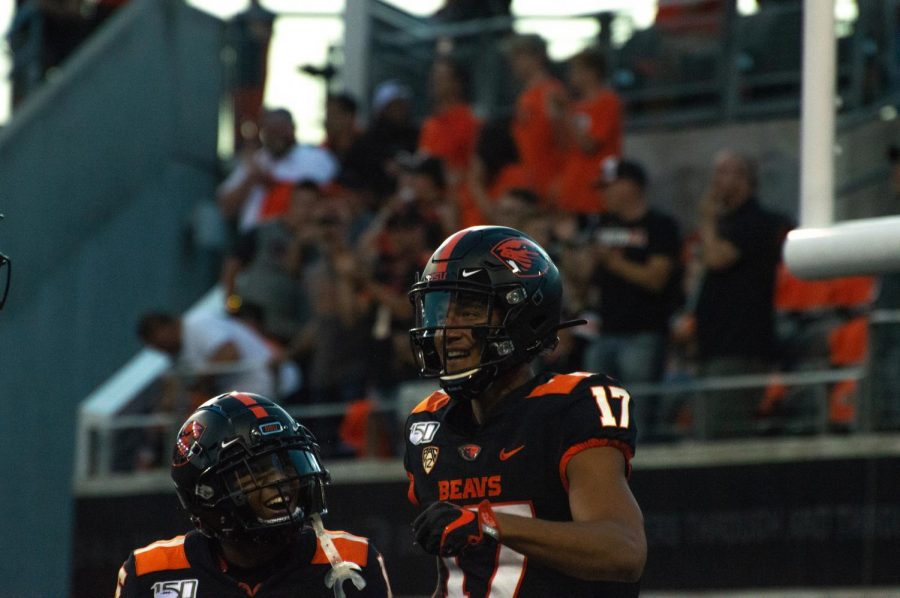 Hodgins shares excitement with a teammate versus Oklahoma State on Aug. 30 where he scored 2 touchdowns. 