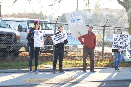 Organizer of the protest and OSU environmental sciences student Emily Barnett (far left) and members of the protest holding up signs protesting Oregon State University’s Clark Meat Lab on Campus Way.