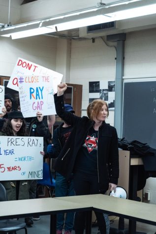 Andrea Haverkamp (center), president of the Coalition of Graduate Employees, raises a fist in the air, signaling a chant to fellow protesters last February.