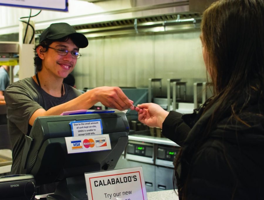 Calabaloo’s student worker Luis Roberts taking food payment from Brooke Sorenson, first year. 