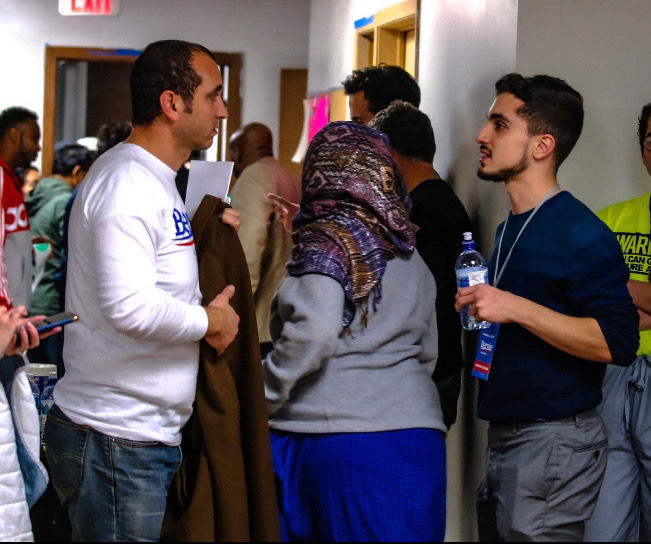 Mohammed Shakibnia, right, speaks with Mohamed Ali, one of the volunteers working with Shakibnia when he was a precinct captain in Iowa at one of the Muslim satellite caucuses.