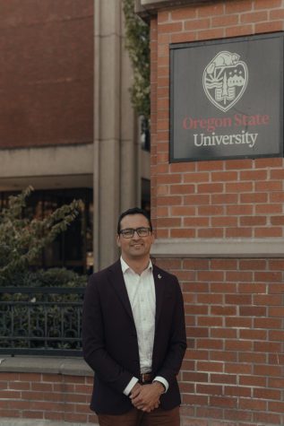 Scott Vignos stands before an Oregon State University sign near the Kerr Administration building, where the Office of Institutional Diversity is located. Vignos has served as vice president and chief diversity officer since November 2022.