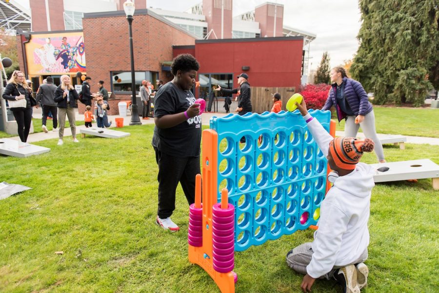 Two participants of the Multicultural Tailgater on Oct. 12, 2019 play a large game of Connect Four near the Centro Cultural César Chávez. The 2021 Multicultural Tailgater will also include yard games like Jenga and Connect Four.