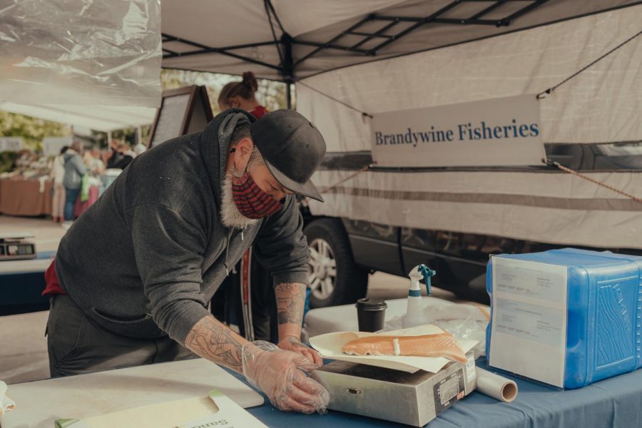 A+vendor+at+the+farmers%E2%80%99+market%2C+Sam+from+Brandywine+Fisheries%2C+weighing+salmon+on+Oct.+9.+Salmon+is+integral+to+Indigenous+cuisine+in+the+Pacific+Northwest.