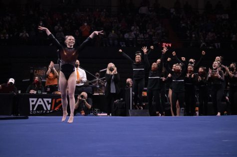 Oregon State freshman all-around gymnast Jade Carey sticking her landing with her teammates watching on in the Beaver tri-meet against the UCLA Bruins and the University of California, Davis Aggies in Corvallis, Ore. on Jan 23, 2022. Carey would set a program record of 39.8 points, and the Beavers would score an overall team score of 197.00 to win the tri-meet against the Bruins (196.300) and the Aggies (194.700)
