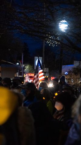 A lone American flag rises above a crowd of candles during the insurrection anniversary vigil at the Benton County Courthouse on Jan. 6. The vigil garnered a group of about 200 people.