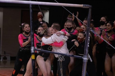 Jade Carey celebrates with her team after her performance on the uneven bars, earning a perfect score for Oregon State.