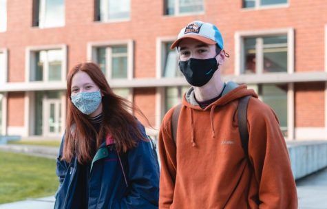 Oregon State University students Makena Apau, left, and Ethan Thompson are wearing masks as they walk out of the Learning Innovation Center on the Corvallis, Ore. campus on Jan. 31. OSU announced on Feb. 24 that it will lift its mask mandate by March 19 at the latest. 