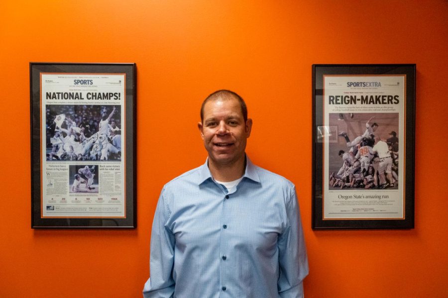 Deputy Athletics Director and Chief Operating Officer at Oregon State University Kimya Massey posing in his office next to OSU memorabilia. Massey supports student-athletes at OSU by serv- ing as the director for various Everyday Champions signature programs.