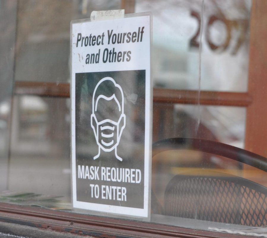A sign to wear masks outside of a barber shop in downtown Corvallis, Ore. on Feb. 14. Small businesses are trying to constantly adapt to alterations in COVID-19 restrictions. 