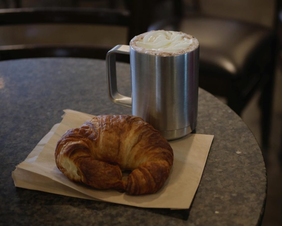 Pictured is a coffee drink in a reusable mug and a croissant from the Cascadia Cafe on March 8. Two on-campus cafes, e.Cafe and Cascadia Cafe, are now offering a 50 cent discount for drink purchases with resuable mugs. 