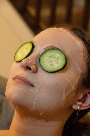 Second-year psychology major Sophia Fischer relaxes while wearing a facemask and cucumbers to soothe her mind while preparing for finals week at her home on March 9. It is important for students to take time for themselves to cool off and calm down, especially during the winter months which can be dark and dreary, physically and mentally. 