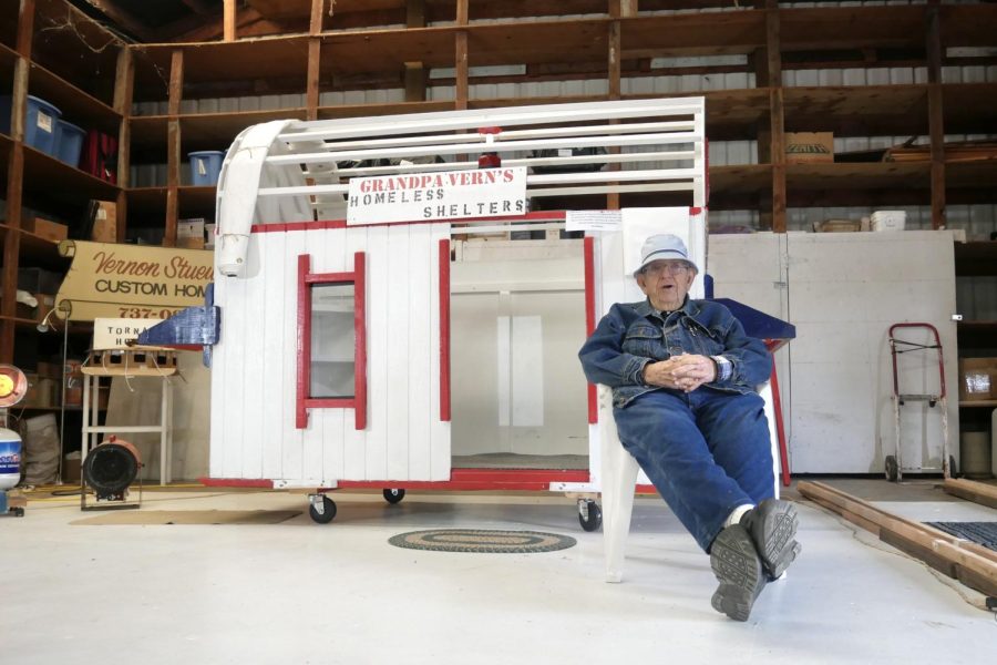 Longtime Corvallis, Ore. resident Vern Stuewe sits in front of his prototype homeless shelter sits on display in the garage surrounded by tools and other projects.