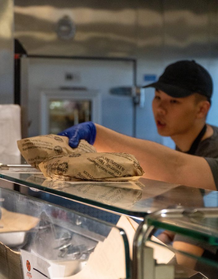 Third-year chemical engineering major, Nicholas Dominic (back), and third-year marketing major, Juan Diego, make sandwiches on April 19 at the Arnold Dining center. Oregon State University is one of the biggest employers of students in Corvallis. 
