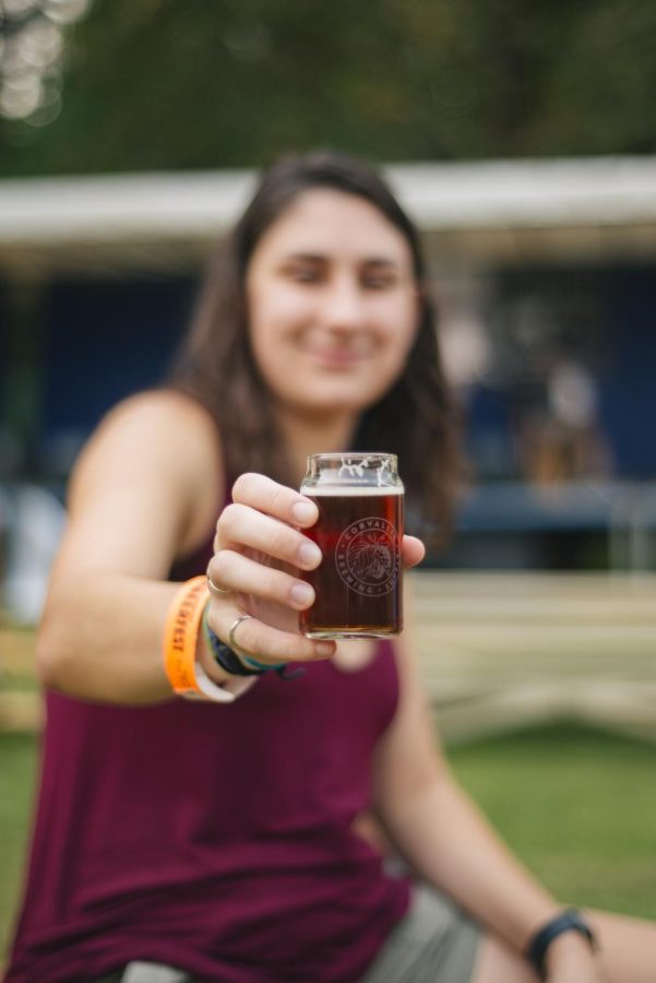 Septembeerfest attendant, Taylor Badigian (she/her) shows her drink in a complimentary glass at Septembeerfest in Avery Park in Corvallis, Ore. on Sept. 10, 2022. The festival featured 20+ breweries local to Oregon.