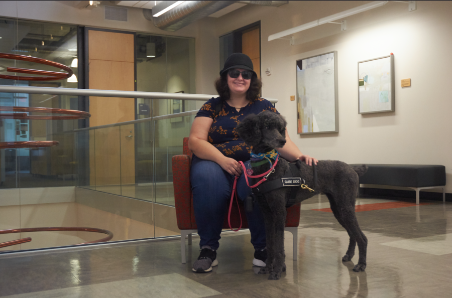 Graduate student, Ashley Neybert, posing with her guide dog, Phoebe, on the third floor of Furman Hall. Neybert is a strong believer in the idea that accommodating disability around campus is beneficial for everybody.