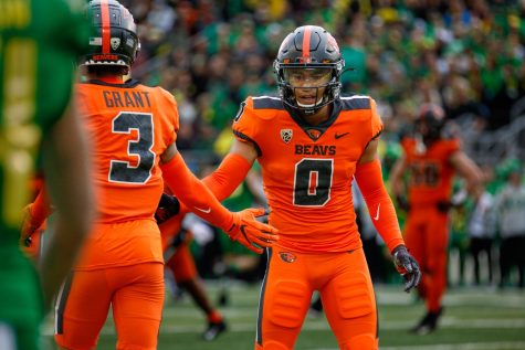 Redshirt sophomore defensive Akili Arnold and redshirt senior defensive back Jaydon Grant meet after a play in last years Rivalry Game in Autzen Stadium on Nov. 27, 2021. This Saturday will be the first time with fans inside Reser Stadium for the Rivalry Game since 2018.