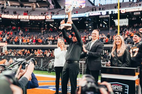 Head coach Jonathan Smith raises the SRS Distribution Las Vegas Bowl trophy after the Beavers won in the game at Allegiant Stadium on Dec. 17. Smith recently signed a $30.6 million contract that will last through the end of the 2028 season.