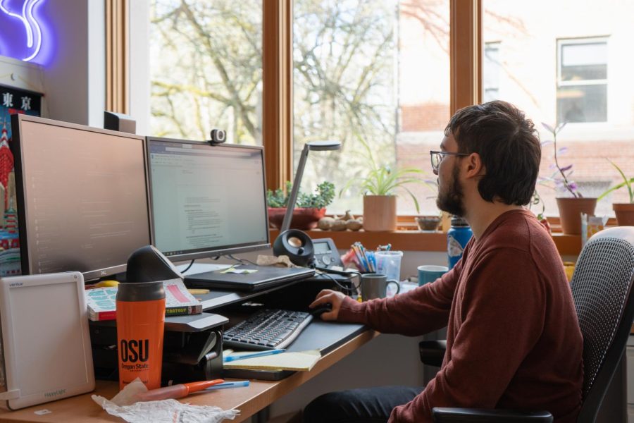 Program Coordinator Clack Chesshir (they/he) sits and does work at their desk at Oregon State University, Feb 13. The Beavs Volunteer team at Community Engagement & Leadership work to deliver an engaging experience that will build community leadership skills.