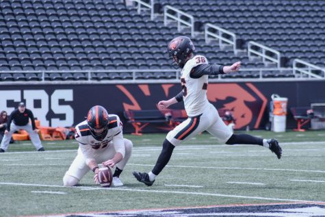Offensive holder Josh Green (left; #37) steadies the ball for kicker Atticus Sappington (#36) on April 22 at Reser Stadium. An annual spring game is held as a sendoff for Beaver Football spring practices with defense taking this year’s victory.
