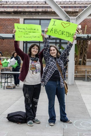 Protesters of the tabling event held by “Students for Life” Rylee (left; preferred not to share their last name; they/them) and Ava (preferred not to share their last name; any/all) pose for an image on May 4 in the SEC Plaza. The “Students for Life” club was tabling with resources in the SEC Plaza while protesters stood across from them.