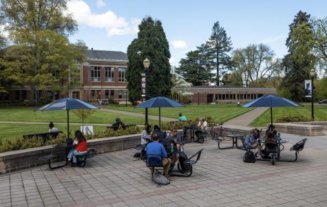 Students and Corvallis community members sit under covered seating in front of the Valley Library on May 9. With weather patterns shifting towards warmer and sunnier days, more and more people seem to be enjoying the outdoor atmosphere.
