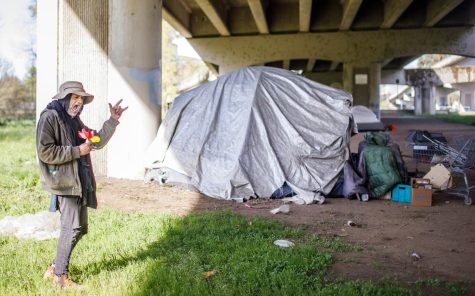 Don, a resident of the camp on the junction of Mary’s River and the Willamette River, collects flowers and poses for a photo on April 26th. Don is irritated about the garbage and trash surrounding his tent, he likes the space he occupies to be tidy. 