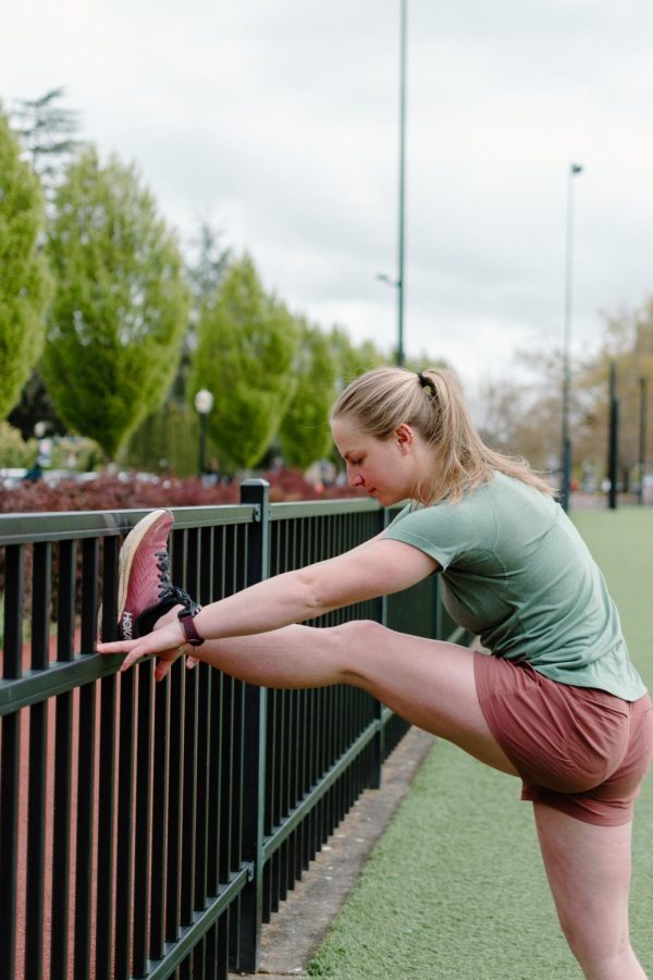 Jalyn Devereaux (she/her) stretches before running on the Intramural Fields on May 4. She ran that morning as part of her training to complete the Corvallis-to-Sea-Trail (C2C), a pathway that links the Willamette Valley and Pacific Ocean.
