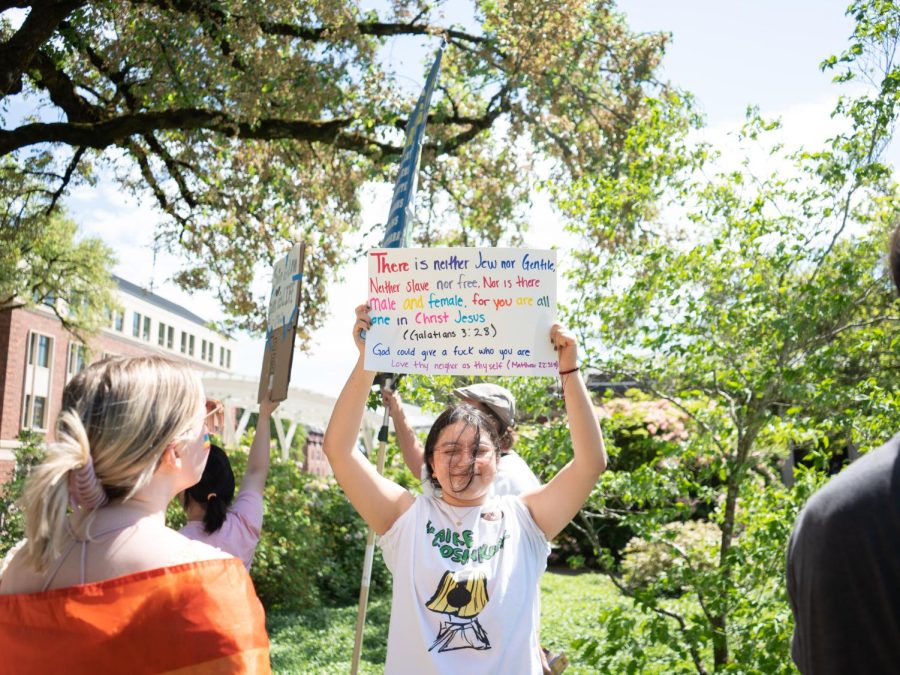 Elizabeth Lopez-Carrera (she/her) holds up a sign to protest against an evangelist on the Memorial Union Quad on May 15. A large crowd of students showed up to protest against the messages the preacher was sharing.