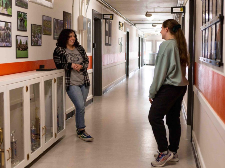 Gabrielle Sanchez (left) and Makayla Steele chatting in the hallway on April 17, 2023 inside McAlexander Fieldhouse. They were discussing their morning run that they are required to do as part of their ROTC training as well as the upcoming 50 years of women in the ROTC celebration event.