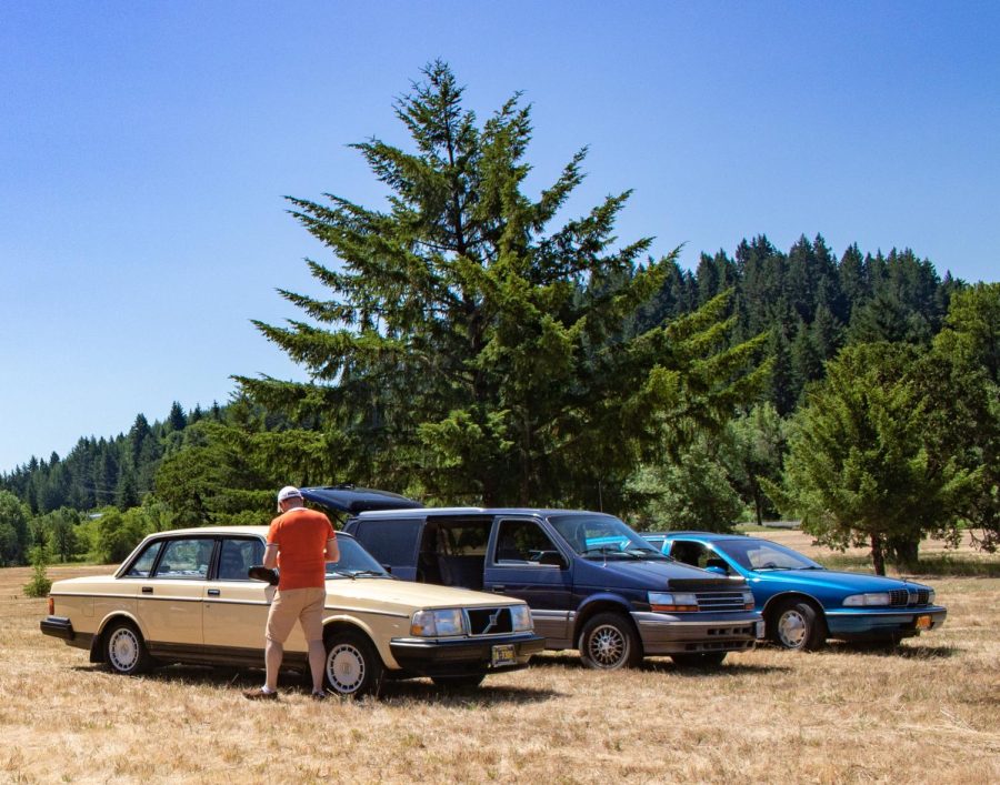 An attendee at the 2nd Annual Malaise Invitational car show in Philomath, Ore. peruses a set of cars on June 24. The car show is open to cars manufactured between the years 1972-1995.