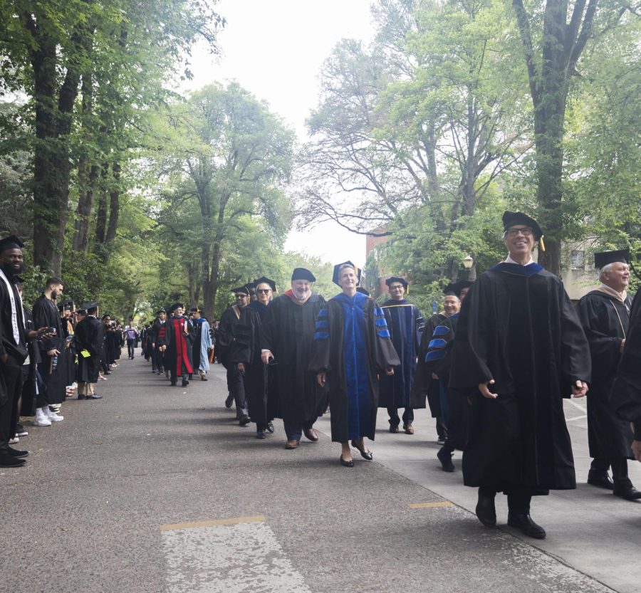 Professors and academic officials greet 2023 graduates as they make their way towards Reser Stadium to attend the graduation ceremony on June 17.