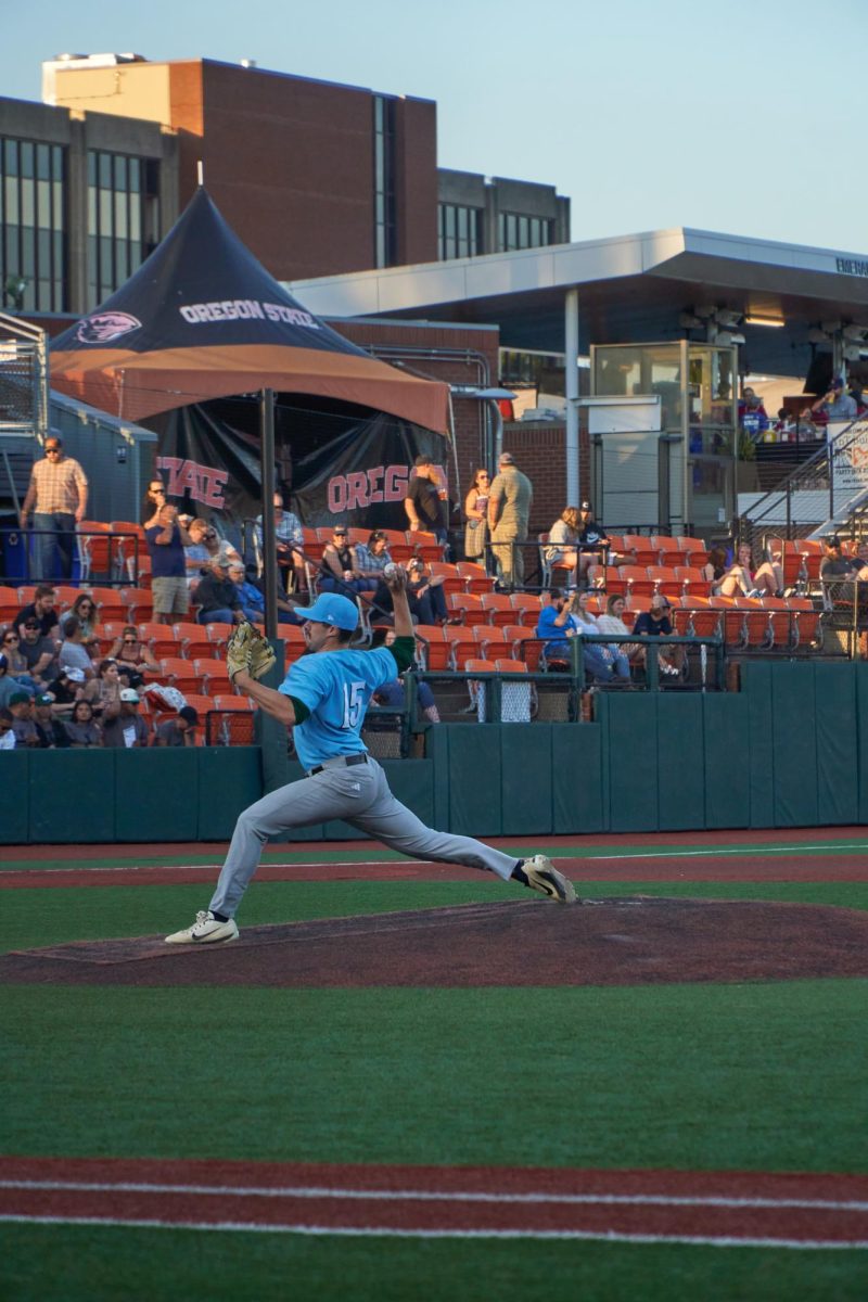 A pitcher for the Yakima Valley Pippins extends his entire body to launch a ball at the opposing batter in a game against the Corvallis Knights at Goss Stadium on July 27, 2023. The Knights secured an 8-2 victory over the Pippins.
