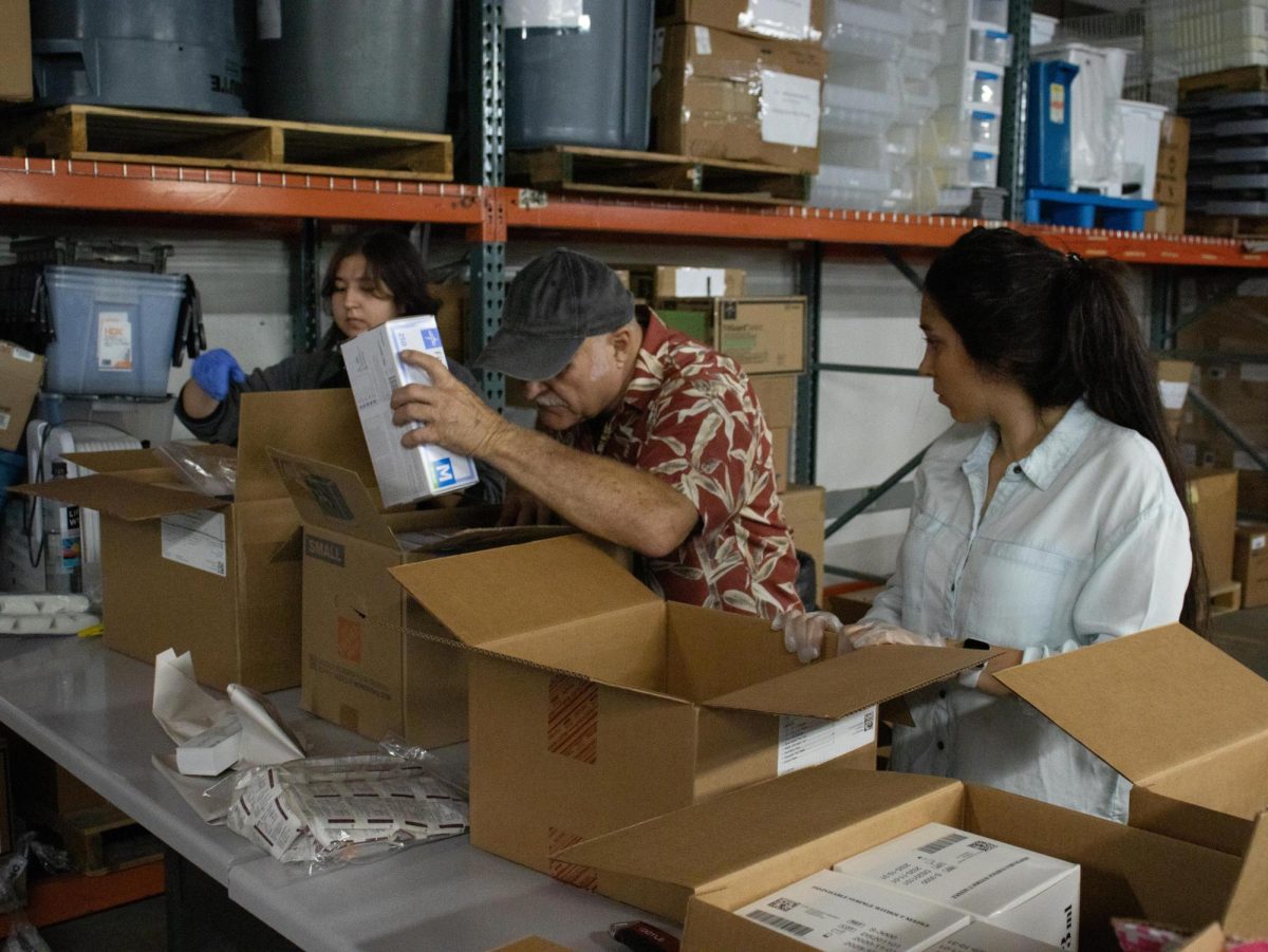 Graphic Design and Business major Ekaterina Dunovskaia (left), Rhawn Krogh (middle) and Sahar Kamalou, Ph.D. in Civil engineering (right) repack boxes of medical supplies at the warehouse on NE Belvue St. in Corvallis on August 24, 2023. Krogh has organized Operation Outreach, and enlisted the help of many international students.