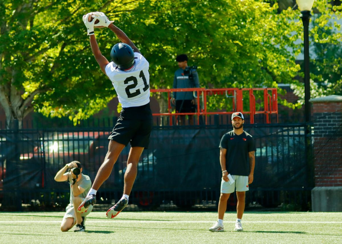 Wide receiver David Wells Jr. (#21) catches a pass during individual position drills while former Oregon State wide receiver Trevon Bradford watches during day one of Oregon State Footballs fall training camp on Aug 3, 2023. Wells is an incoming freshman at Oregon State and a former 3-star recruit in Beaver Footballs 2023 recruiting class. 