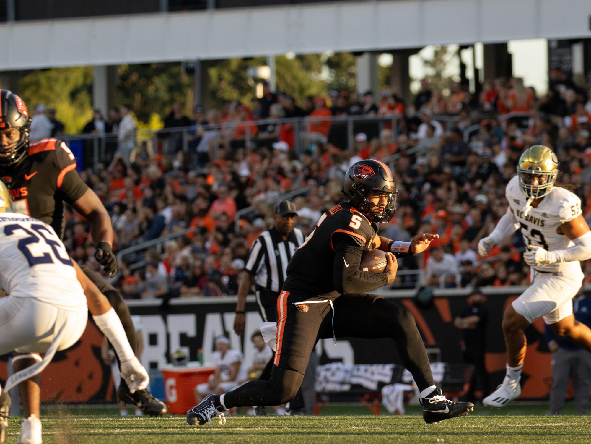 Oregon State quarterback DJ Uiagalelei jukes out a defender on his way to a touchdown in the first quarter of the game against UC Davis in Reser Stadium on August 9 2023. Uiagalelei played only the first half, completing 8 of 13 passes for 107 yards and two touchdowns while adding another on the ground in a 55-7 Beavers win.