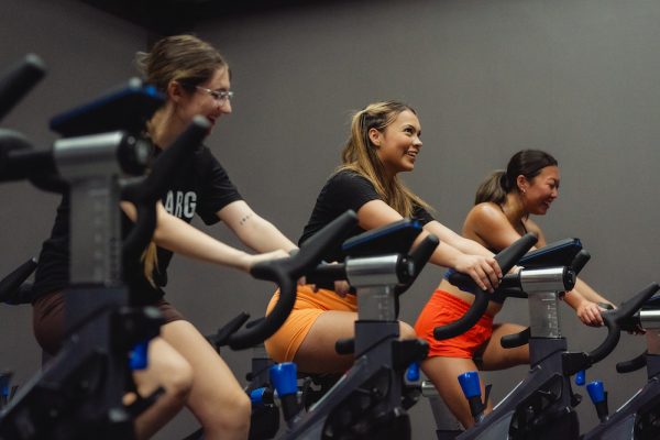 (Left to right) Grace Darazs, Hannah Summers and Jenna Price demonstrate a cycling exercise at Dixon Rec Center on the campus of OSU on Sept. 14. They are the student leaders of CHAARG, a new-to-OSU athletic club targeted towards female-identifying individuals.