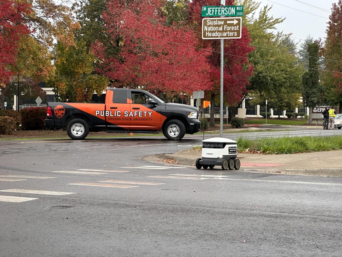 A Starship delivery robot crosses SW Jefferson Way, where OSU Department of Public Safety is conducting an investigation into an ongoing bomb threat.